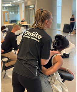 Employee in massage chair at an office, practitioner working shoulders